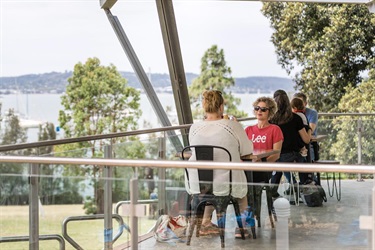 Small groups of people sitting at tables on an elevated balcony