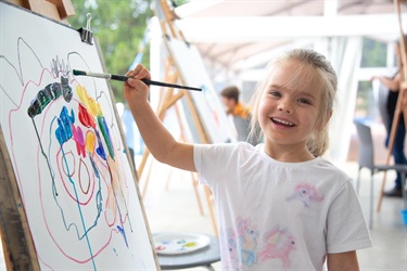 A child smiling as they paint