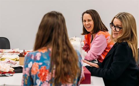 Three women engaging in conversation. 