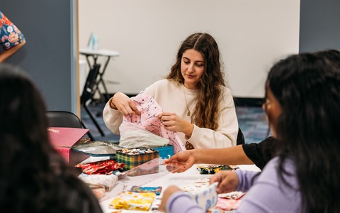 A young woman participates in a sewing workshop. 